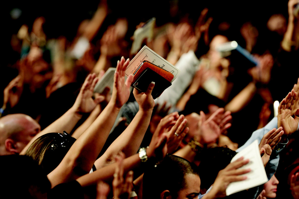 People Raising Bibles Worshiping God